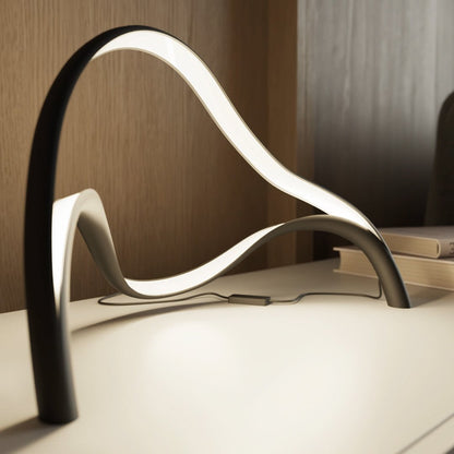 Modern table lamp featuring an integrated LED light with a sleek metal and acrylic finish, designed for compact use on bedside tables or desks. 4