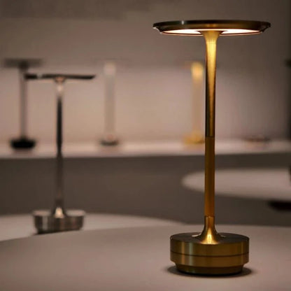 Portable cordless table lamp with adjustable brightness, featuring a sleek metallic finish, ideal for both indoor and outdoor use. 1