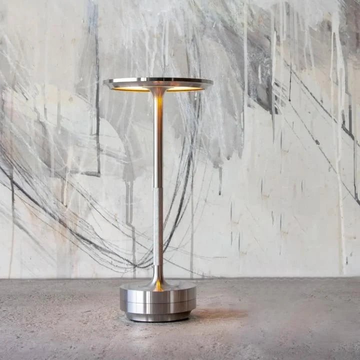 Portable cordless table lamp with adjustable brightness, featuring a sleek metallic finish, ideal for both indoor and outdoor use. 4