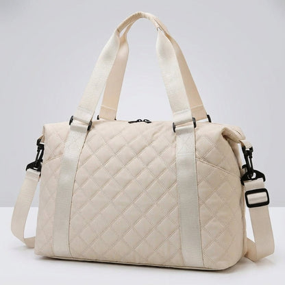 Lightweight quilted weekend bag for women featuring a padded structure and adjustable strap, perfect for stylish travel. 0