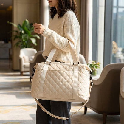 Lightweight quilted weekend bag for women featuring a padded structure and adjustable strap, perfect for stylish travel. 1