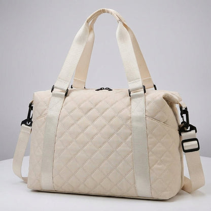 Lightweight quilted weekend bag for women featuring a padded structure and adjustable strap, perfect for stylish travel. 2