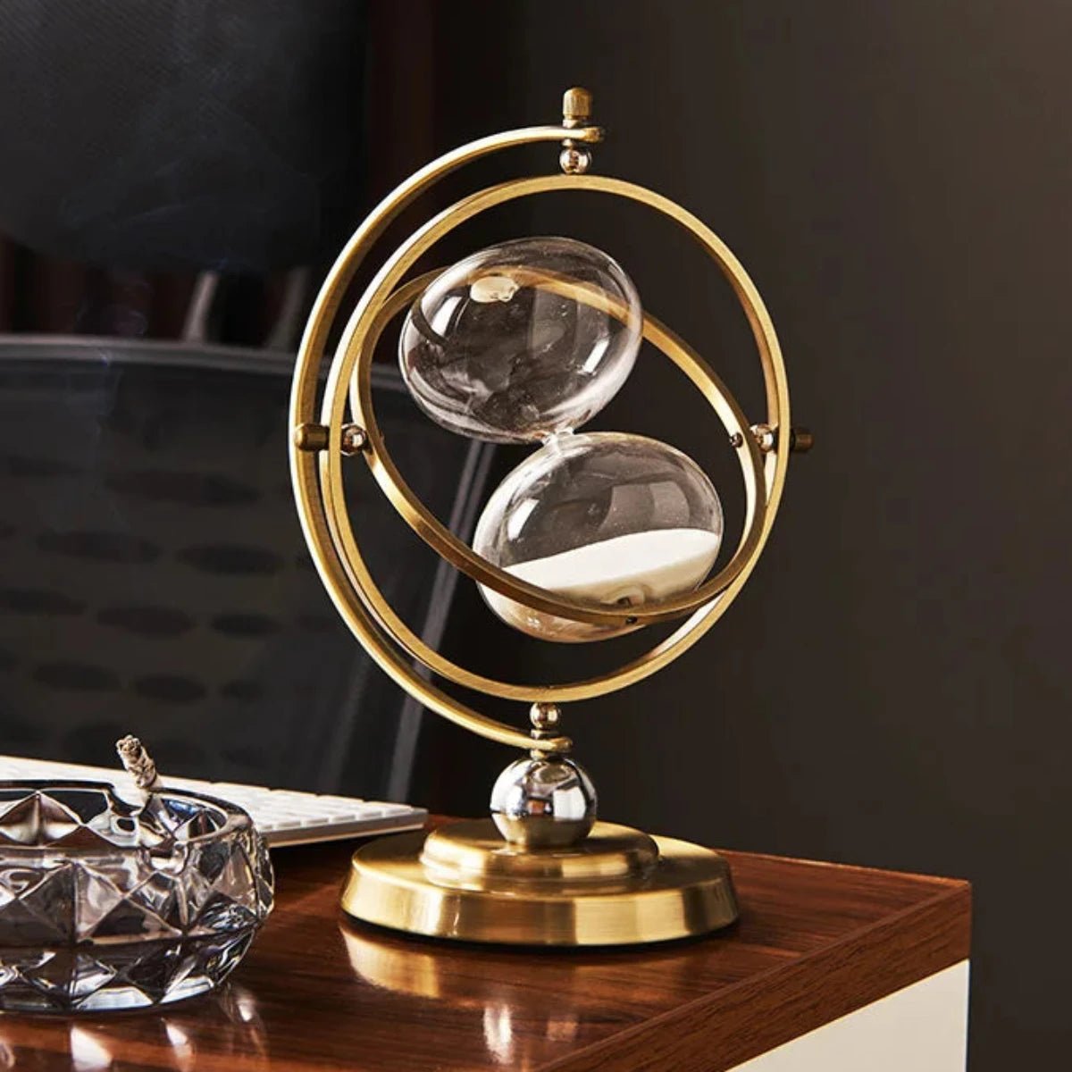Scandinavian metal hourglass timer featuring an elegant brass and glass design, showcasing a stylish gold and white color scheme, perfect for home decor. 2