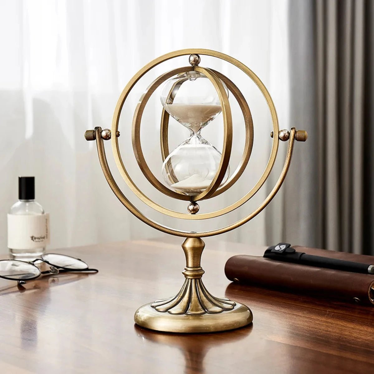 Scandinavian metal hourglass timer featuring an elegant brass and glass design, showcasing a stylish gold and white color scheme, perfect for home decor. 0