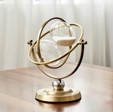 Scandinavian metal hourglass timer featuring an elegant brass and glass design, showcasing a stylish gold and white color scheme, perfect for home decor. 3