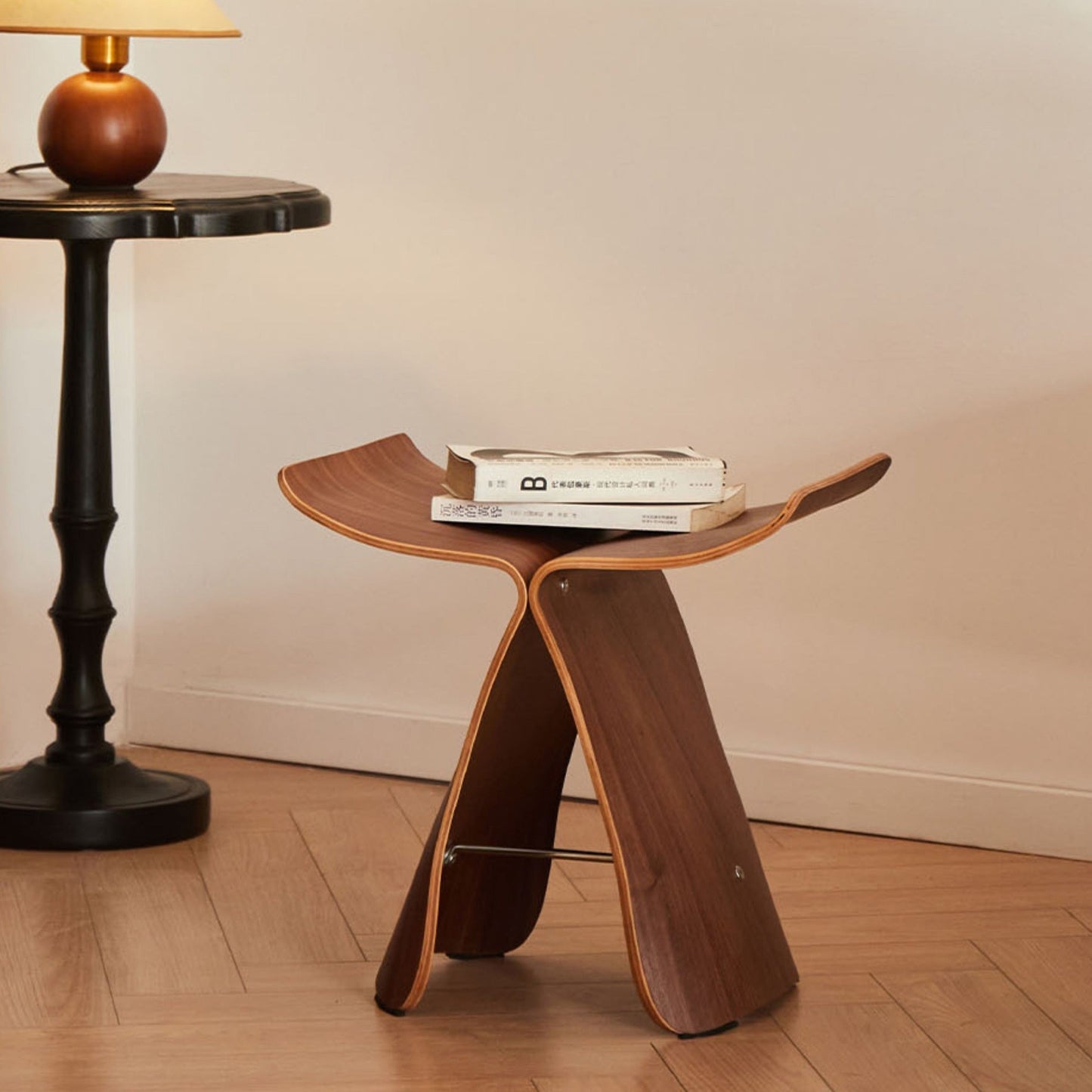 Solid wood butterfly stool with a natural finish, featuring a timeless design for compact and versatile seating in any space. 1