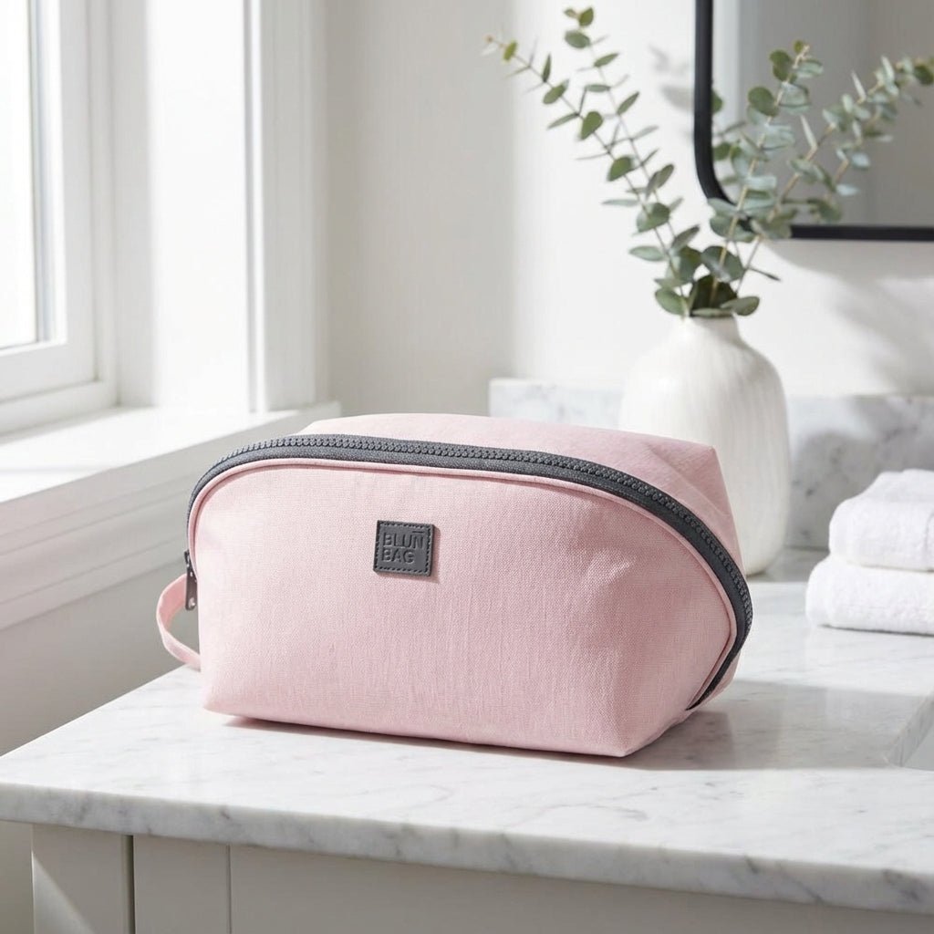 Light pink nylon travel toiletry bag featuring smart compartments and a wide opening, perfect for organizing cosmetics and personal care items while on the go. 1