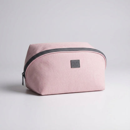 Light pink nylon travel toiletry bag featuring smart compartments and a wide opening, perfect for organizing cosmetics and personal care items while on the go. 2