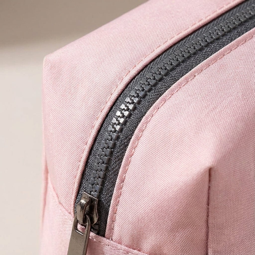 Light pink nylon travel toiletry bag featuring smart compartments and a wide opening, perfect for organizing cosmetics and personal care items while on the go. 3