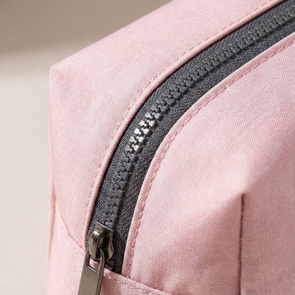 Light pink nylon travel toiletry bag featuring smart compartments and a wide opening, perfect for organizing cosmetics and personal care items while on the go. 3