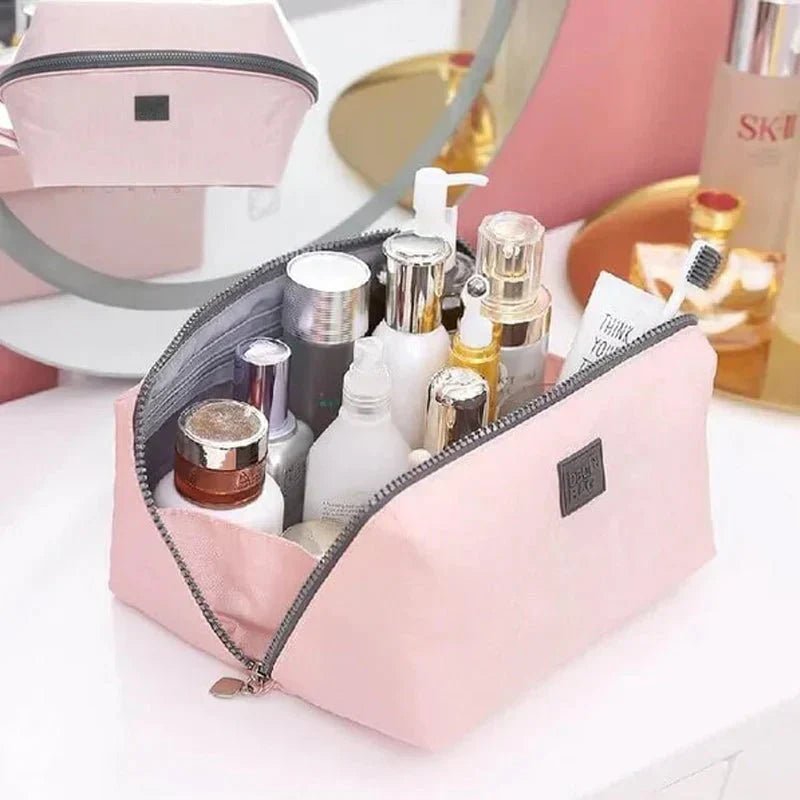 Light pink nylon travel toiletry bag featuring smart compartments and a wide opening, perfect for organizing cosmetics and personal care items while on the go. 4