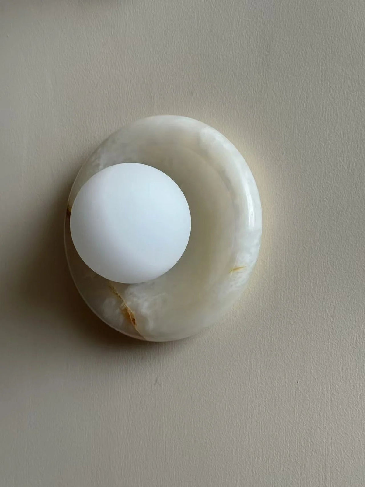 Wall light featuring a natural onyx backplate and a stylish glass globe, designed for hardwired indoor installation, perfect for enhancing home decor. 46