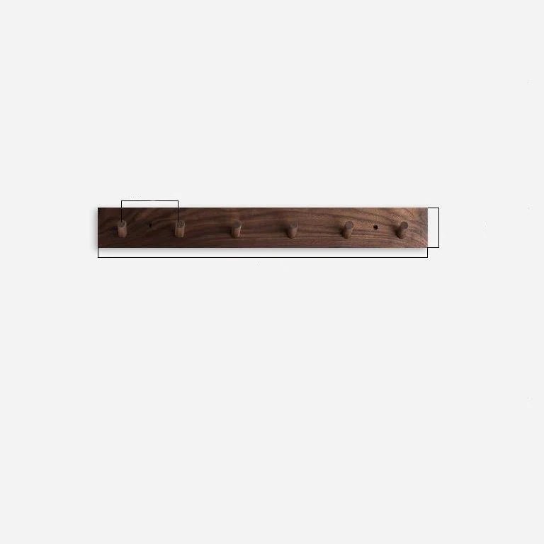Wall mounted coat rack featuring round pegs, crafted from minimalist solid wood in walnut or beech, perfect for modern entryway decor. 5
