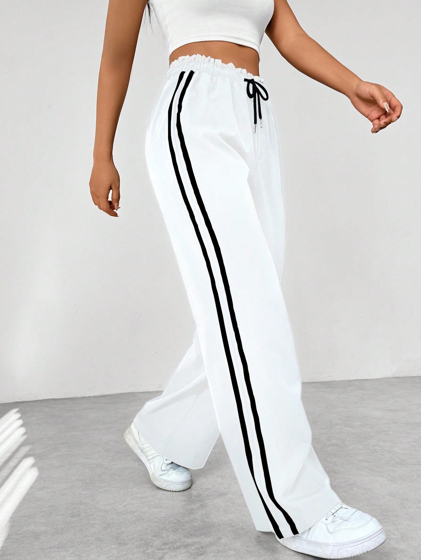 Wide leg trousers for women featuring sporty side stripes, crafted from airy fabric with an elastic waistband for comfort and style. 4