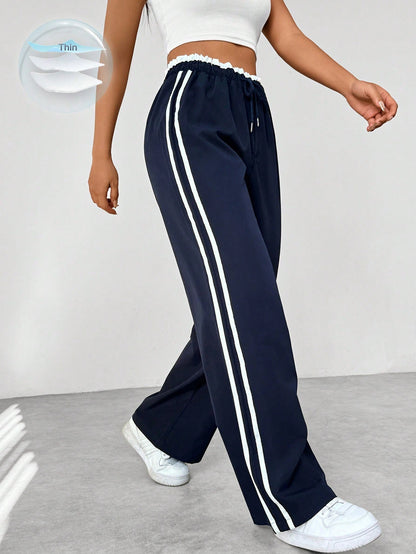 Wide leg trousers for women featuring sporty side stripes, crafted from airy fabric with an elastic waistband for comfort and style. 0