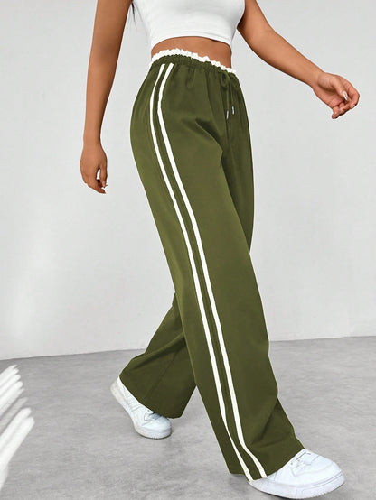 Wide leg trousers for women featuring sporty side stripes, crafted from airy fabric with an elastic waistband for comfort and style. 7