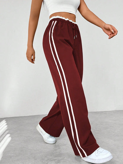 Wide leg trousers for women featuring sporty side stripes, crafted from airy fabric with an elastic waistband for comfort and style. 8