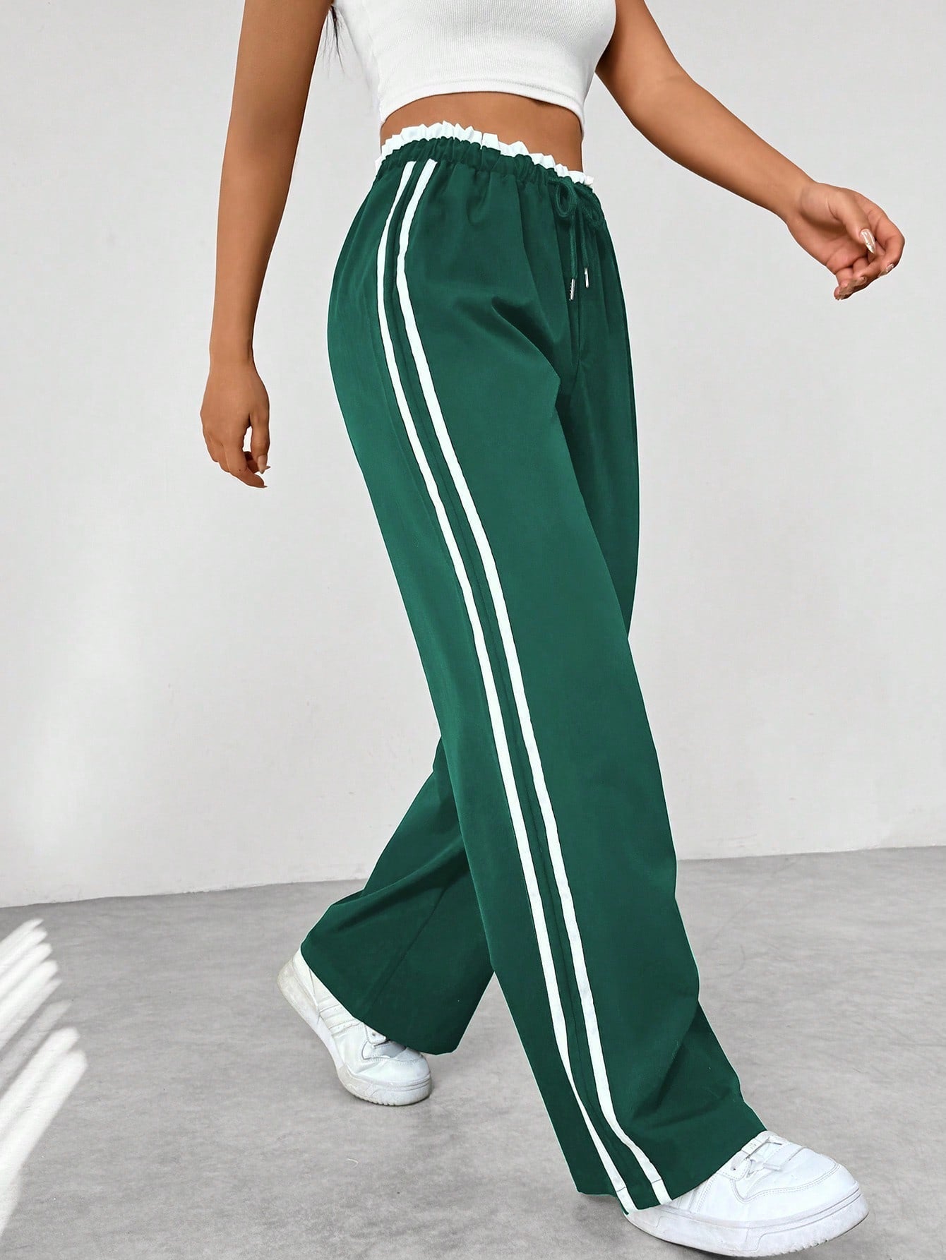 Wide leg trousers for women featuring sporty side stripes, crafted from airy fabric with an elastic waistband for comfort and style. 6