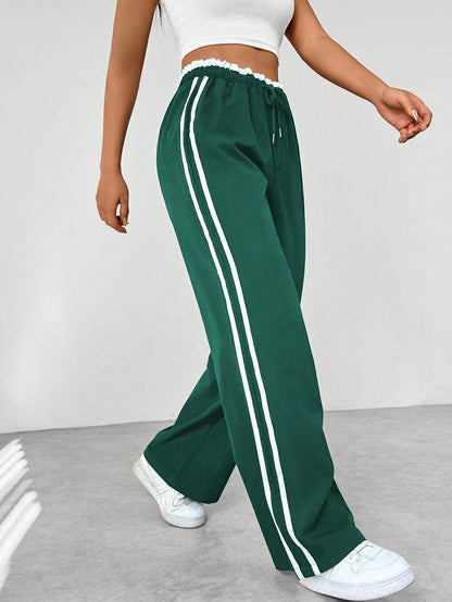 Wide leg trousers for women featuring sporty side stripes, crafted from airy fabric with an elastic waistband for comfort and style. 6
