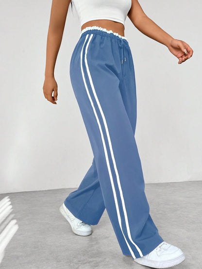 Wide leg trousers for women featuring sporty side stripes, crafted from airy fabric with an elastic waistband for comfort and style. 1