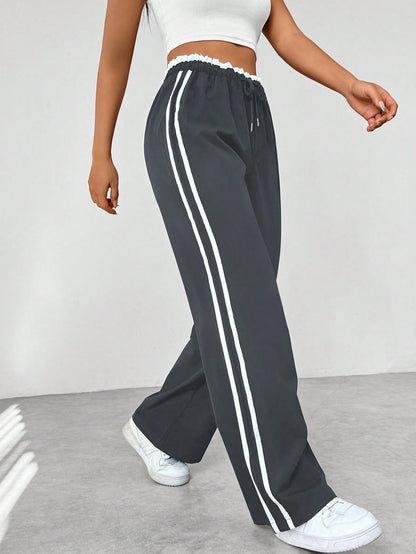 Wide leg trousers for women featuring sporty side stripes, crafted from airy fabric with an elastic waistband for comfort and style. 3