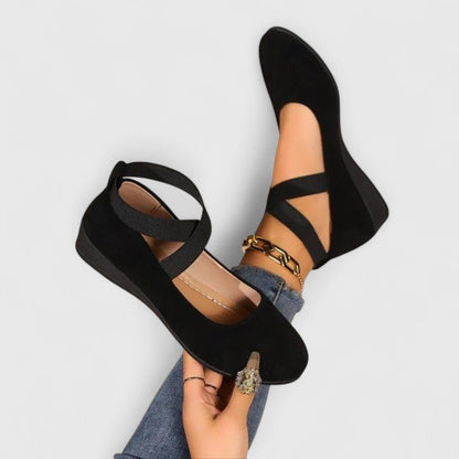 Women's black ballet flats featuring arch support and an adjustable cross-strap for enhanced comfort and orthopedic design. 0