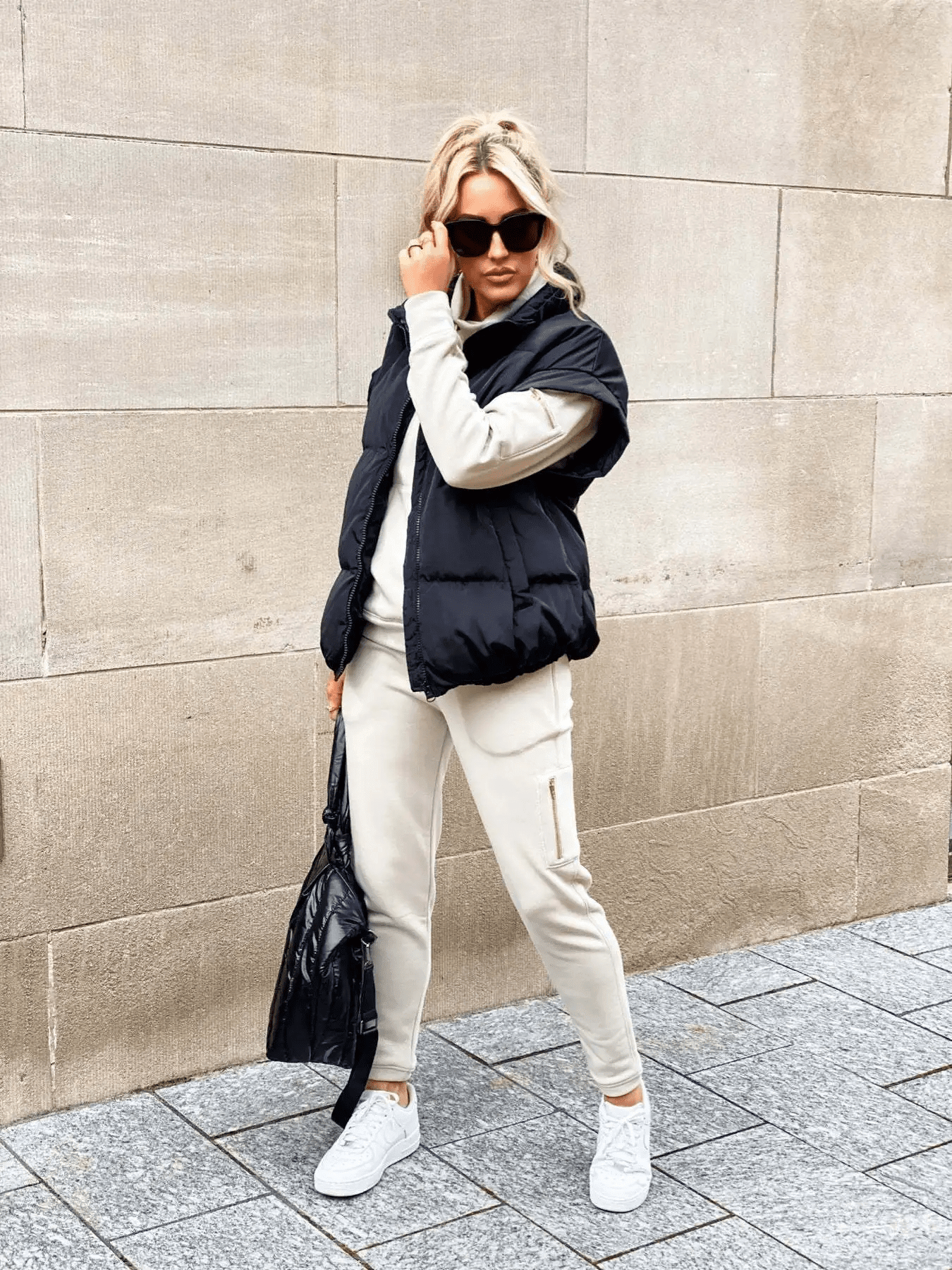 Women's black puffer vest featuring a high stand collar and zip front, designed for lightweight warmth and stylish layering. 3