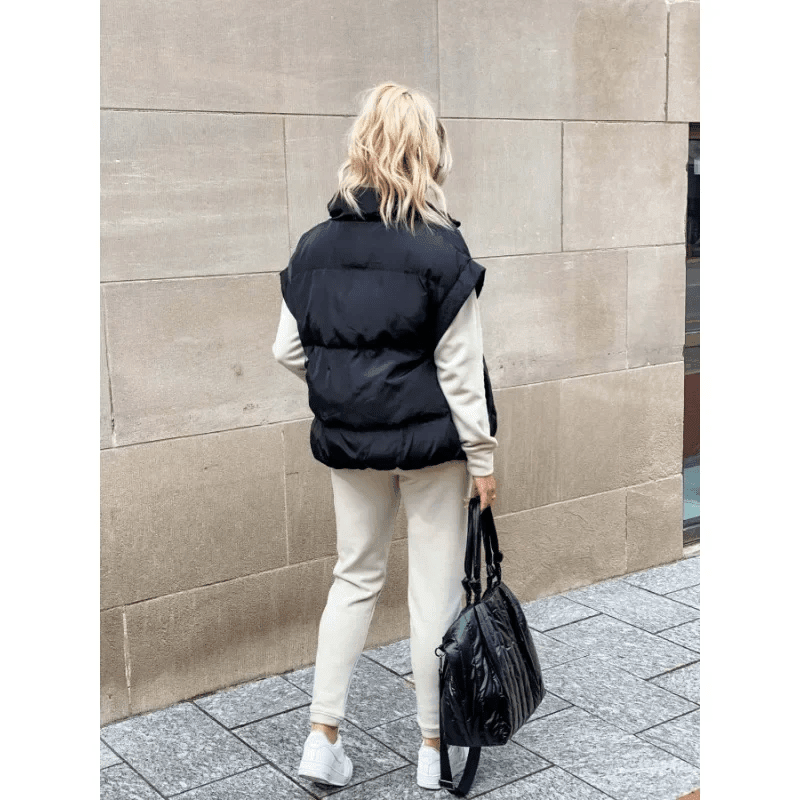 Women's black puffer vest featuring a high stand collar and zip front, designed for lightweight warmth and stylish layering. 4