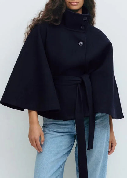 Women's cape coat featuring an adjustable waist belt and high neck, designed for elegant winter layering in a soft polyester blend fabric. 4