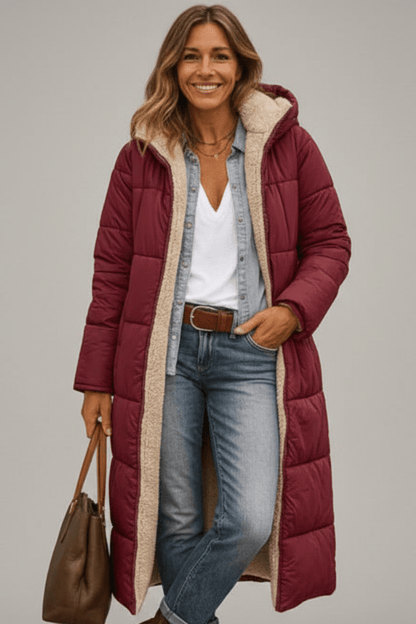 Women's quilted long winter coat with fixed hood and zip closure, designed for warmth and style during cold weather. 7