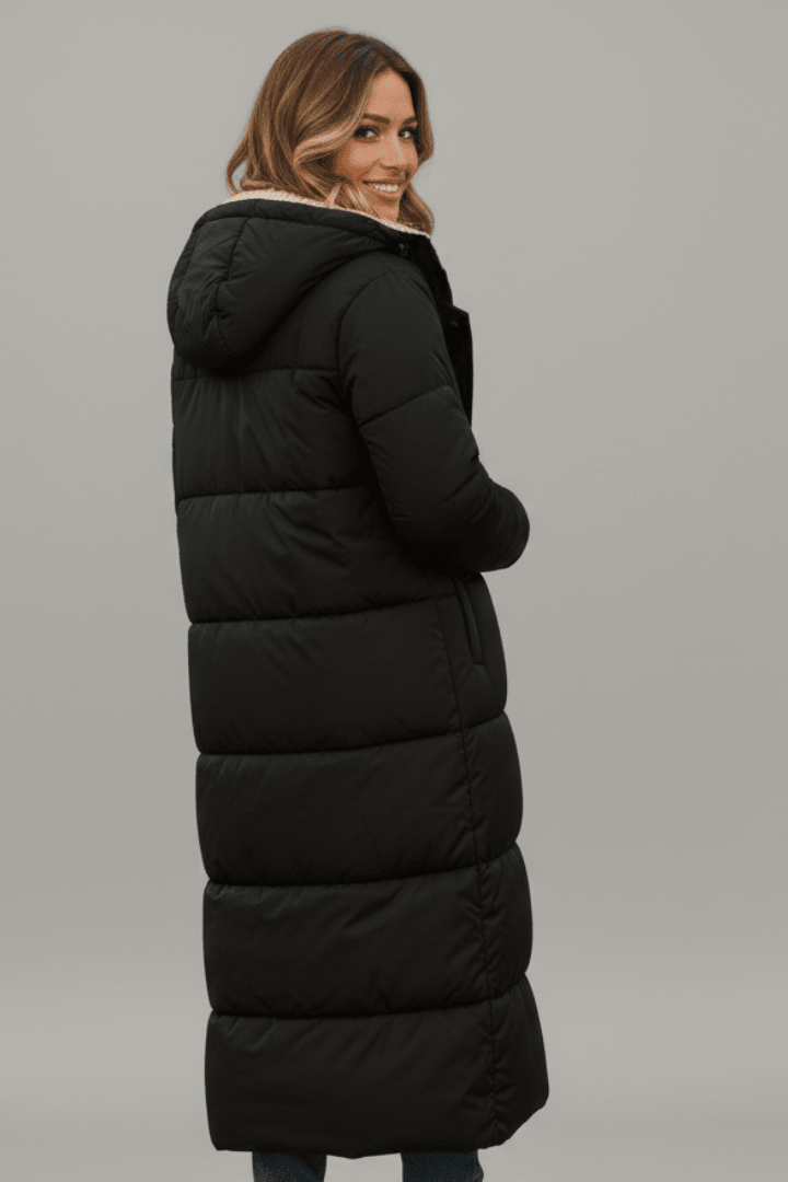 Women's quilted long winter coat with fixed hood and zip closure, designed for warmth and style during cold weather. 3