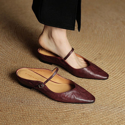 Women's black leather flats featuring a buckle strap and pointed-toe slip-on Mary Jane design, perfect for stylish and comfortable everyday wear. 1