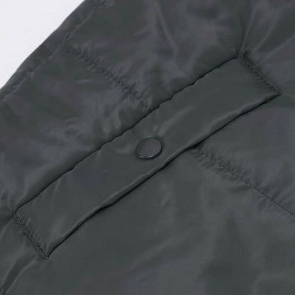 Women's longline quilted puffer jacket in black, featuring a zip front and practical pockets, ideal for cold weather wear. 2