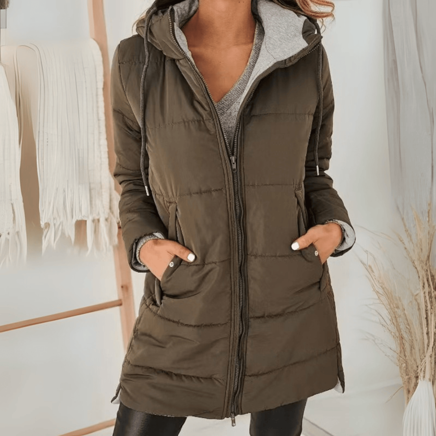 Women's longline quilted puffer jacket in black, featuring a zip front and practical pockets, ideal for cold weather wear. 4