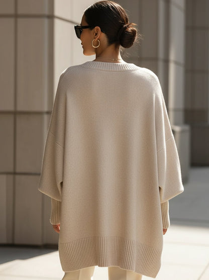 Women's oversized sweater in beige with an asymmetrical hem, made from a cozy wool blend, perfect for stylish layering and comfort in cooler weather. 3