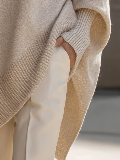 Women's oversized sweater in beige with an asymmetrical hem, made from a cozy wool blend, perfect for stylish layering and comfort in cooler weather. 4