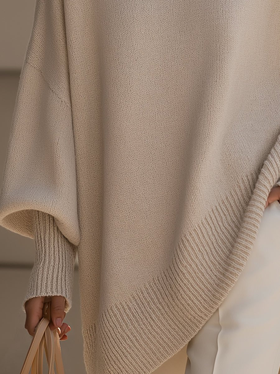 Women's oversized sweater in beige with an asymmetrical hem, made from a cozy wool blend, perfect for stylish layering and comfort in cooler weather. 2