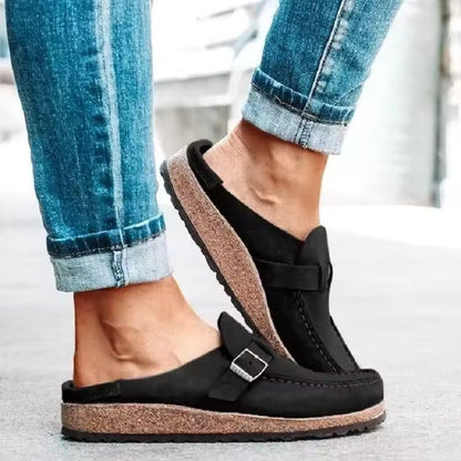 Women's black slip-on loafers featuring a modern buckle design, cushioned sole, and platform for enhanced comfort and style. 1