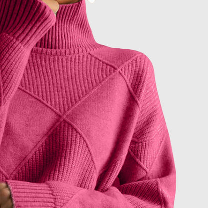 Women’s rose-colored sweater featuring a stylish geometric pattern and a cozy turtleneck design, perfect for comfortable layering in cooler weather. 2