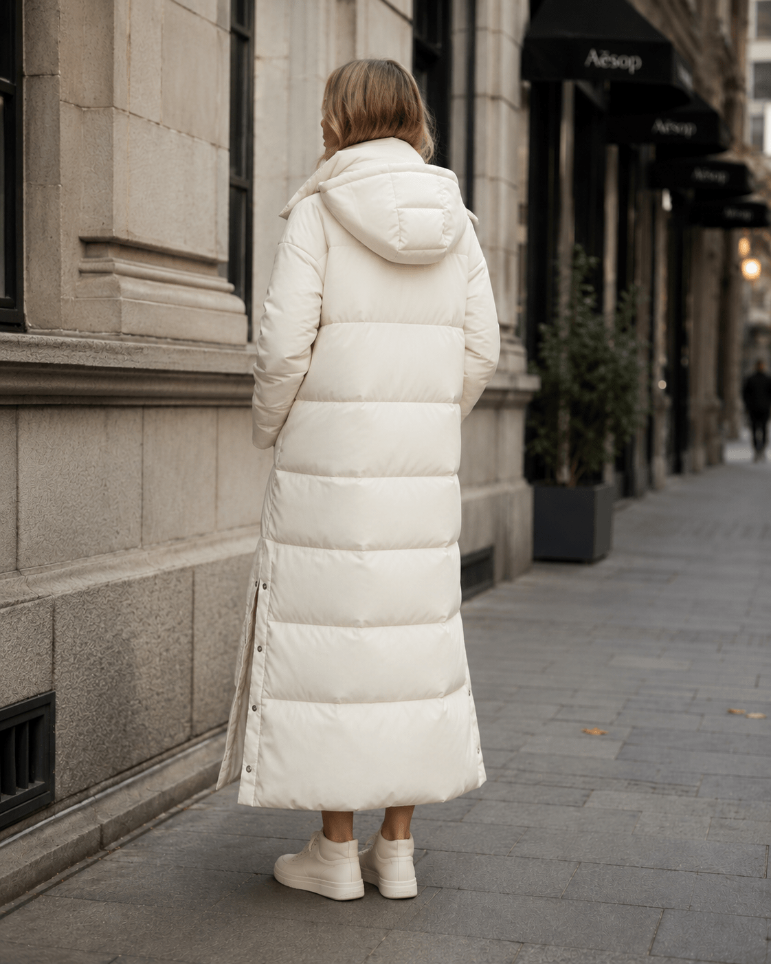 Women's windproof winter jacket featuring an extended length and relaxed fit, designed for durability and warmth in cold weather conditions. 2
