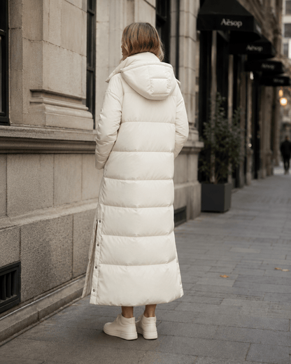 Women's windproof winter jacket featuring an extended length and relaxed fit, designed for durability and warmth in cold weather conditions. 2