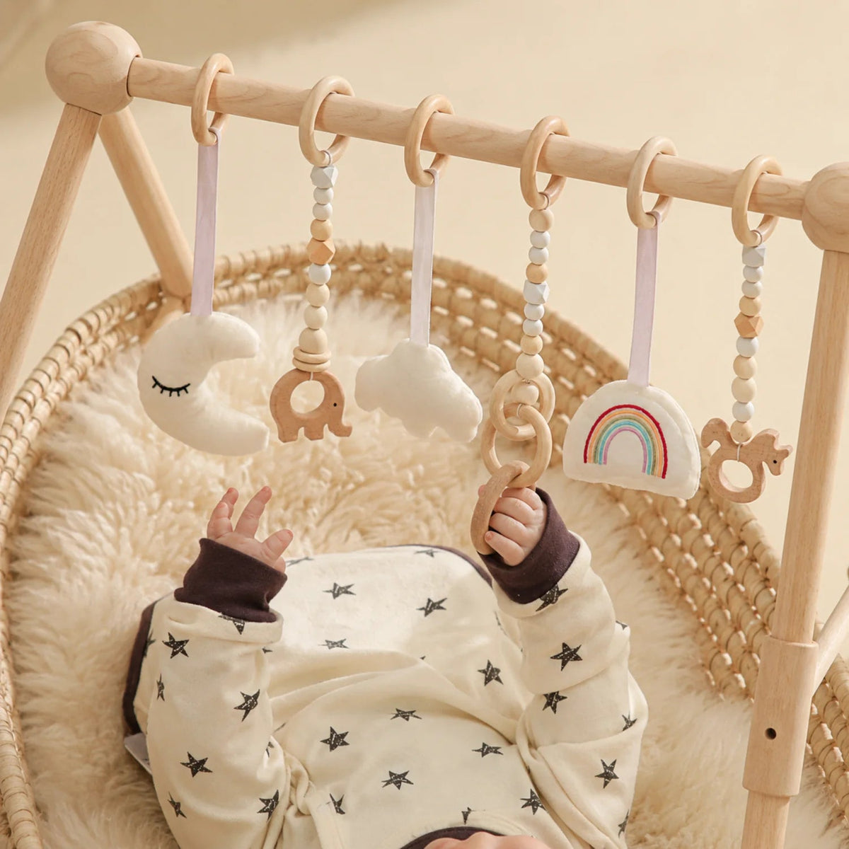 Wooden baby play gym featuring a natural wood minimalist design, equipped with colorful sensory toys for newborn and infant development. 2